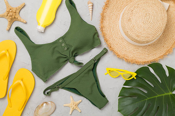 Flat lay with colorful beach accessories on concrete background.