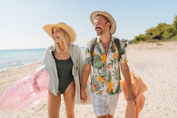 Photo of a smiling couple arriving at the beach.